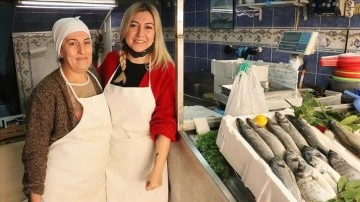 İki kadın dal omuza balık satarak ekmeklerini çıkarıyor