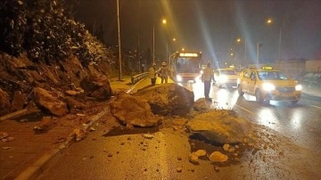 İzmir'de yağmur zımnında koparak yola sakıt kaya parçaları tempo halindeki arabaya dokunca verd