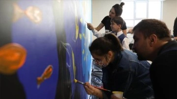 Özel öğrenciler, okullarının duvarlarını kişi elleriyle boyadı